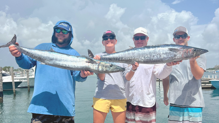 fishing participants holding up their wahoo on the dock for a picture