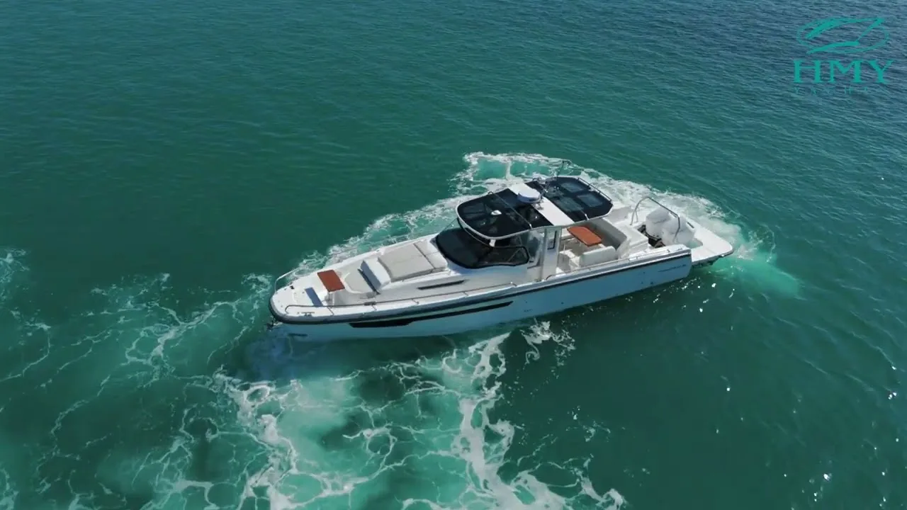Aerial view of the Nimbus 42 Sport Tender day boat underway on green water, with the HMY Yacht Sales logo.