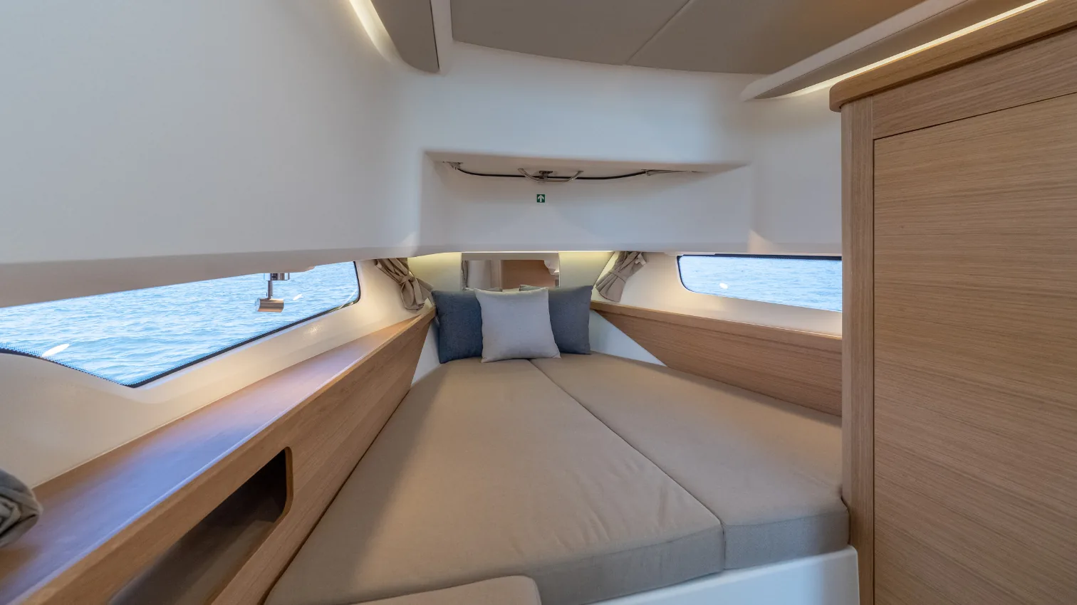 Nimbus T11 overnight cabin with a double berth and natural light from the hull windows.